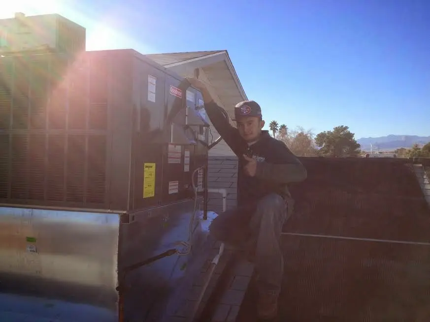 HVAC technician performing Heat Pump Repair on a rooftop unit in Robbinsdale